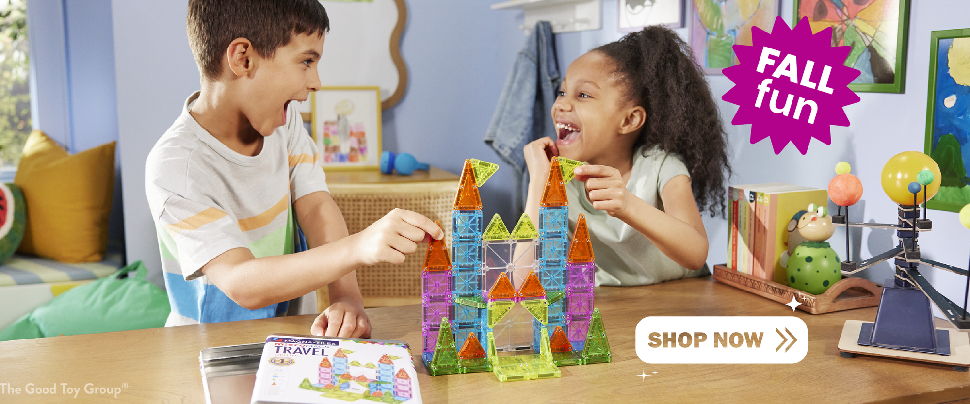 Two children playing with colorful Magna-Tiles in a room with toys and decorations.